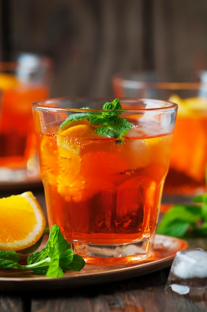 Vaso de aperol con hielo, naranja y menta.