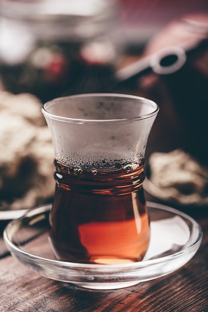 Vaso Armudu con té negro con utensilios de cocina en la mesa