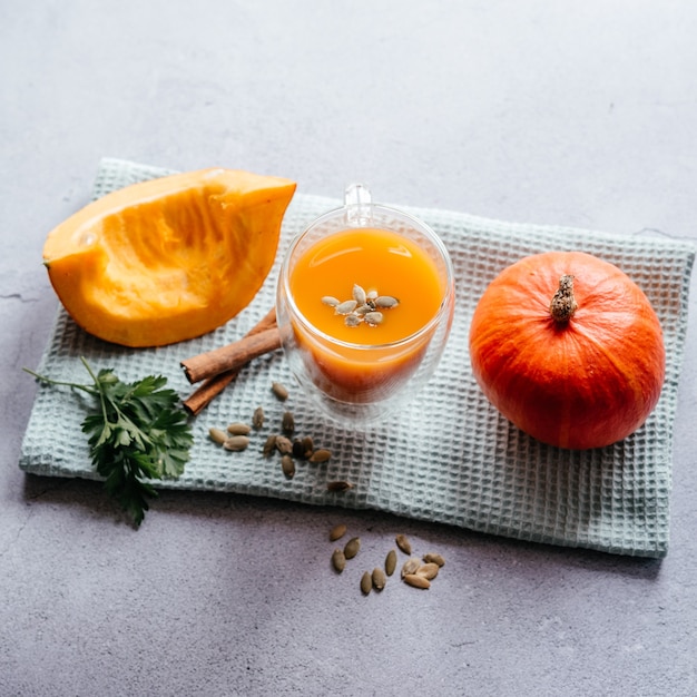 Un vaso de batido de calabaza fresca con calabaza ve, perejil y vista superior de canela