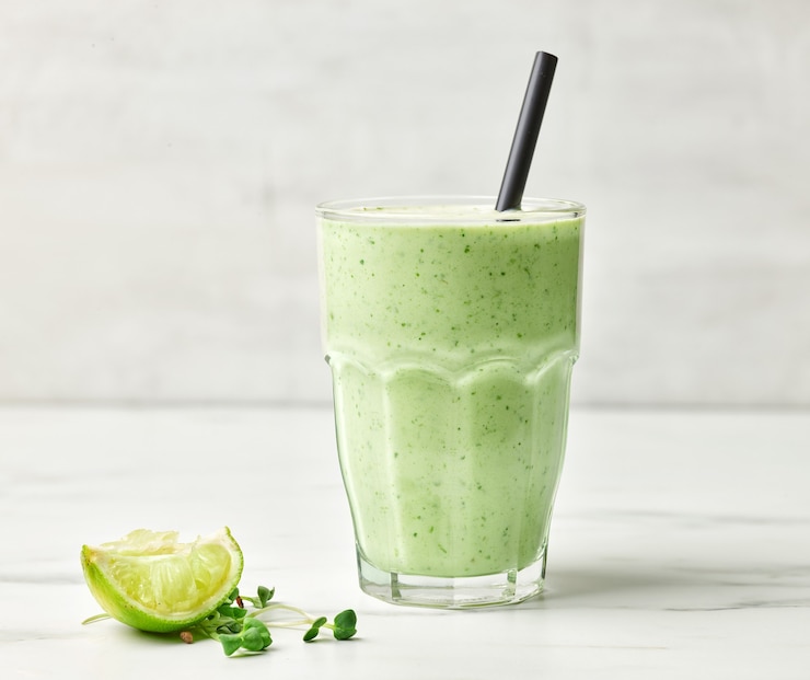 Foto vaso de batido de desayuno saludable verde en la mesa de la cocina