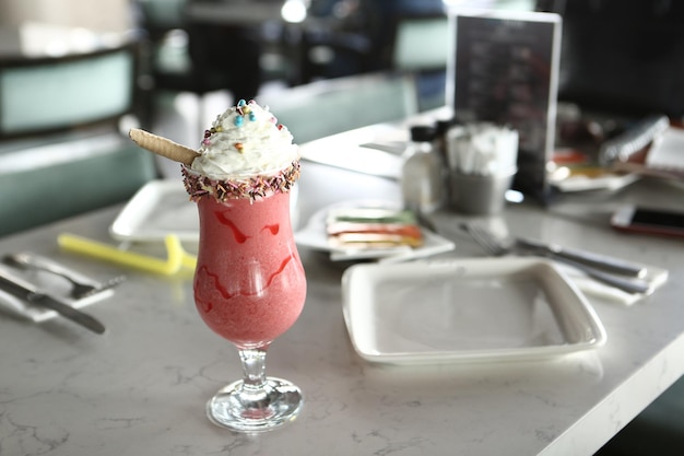 Vaso de batido de frambuesa con crema batida y frambuesas frescas