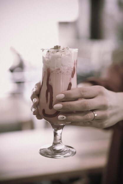 Vaso de batido de frambuesa con crema batida y frambuesas frescas