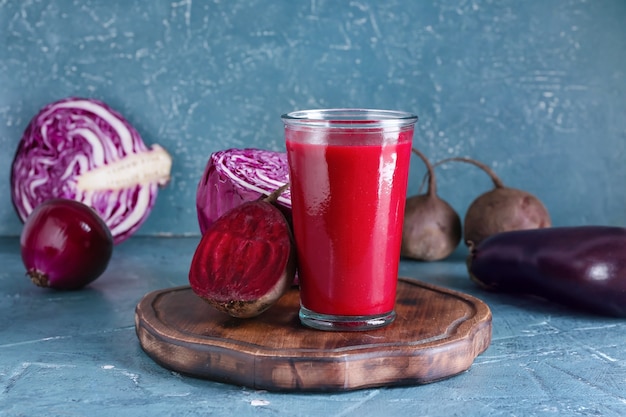 Vaso de batido saludable con verduras en la superficie de color