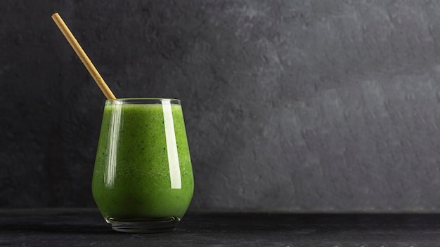 Vaso con batido verde de espinacas, manzana, pepino en clave de ley oscura