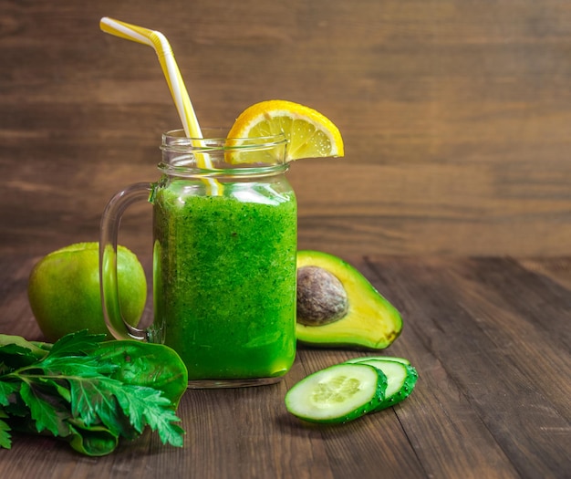 Un vaso de batido verde con pajita y una pajita amarilla.