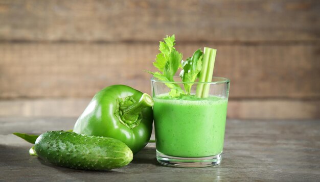 Vaso de batido de verduras frescas en la mesa de madera