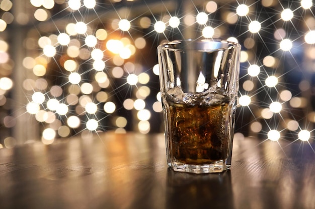 Vaso de bebida alcohólica fría con hielo sobre la mesa