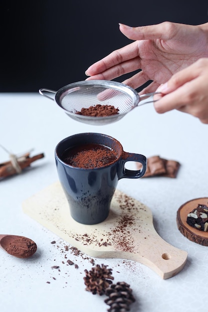 Vaso de bebida de cacao con chocolate caliente espolvoreado con cacao en polvo.