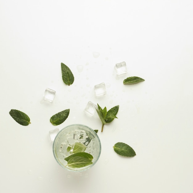 Vaso con una bebida refrescante con menta y hielo en una luz. Vista plana, vista superior