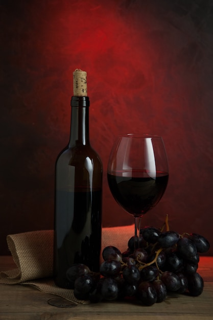 Foto vaso y una botella de vino tinto español