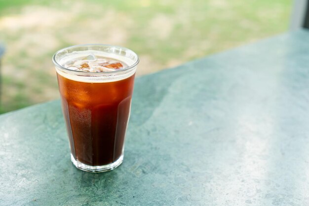 Vaso de café americano helado en la mesa