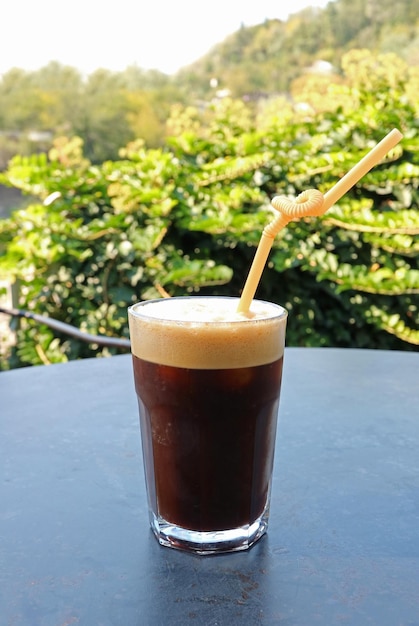 Vaso de café espumoso helado aislado en la mesa de jardín