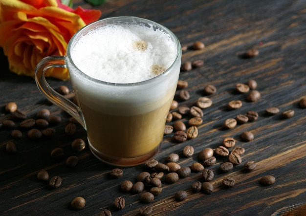 Un vaso de café con una flor roja dentro