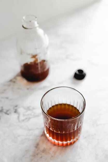 Un vaso de café frío y una botella.