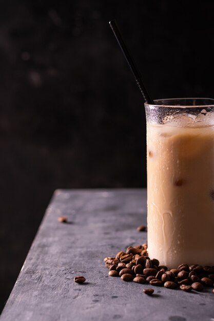 Un vaso de café helado en una mesa, espacio para copiar texto