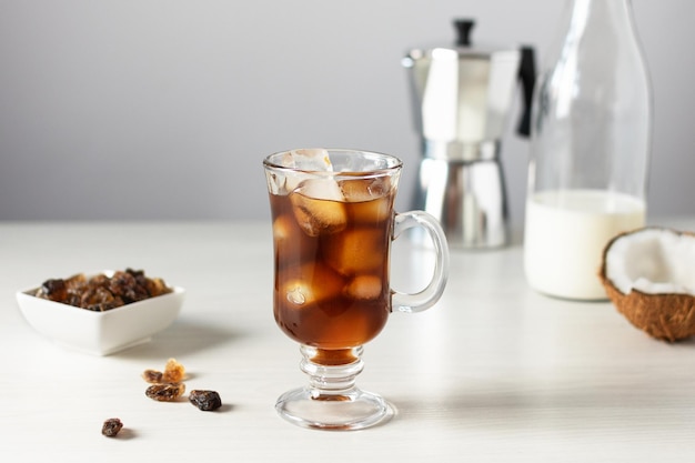 Un vaso de café helado en una mesa de madera blanca Refresco frío bebida de verano