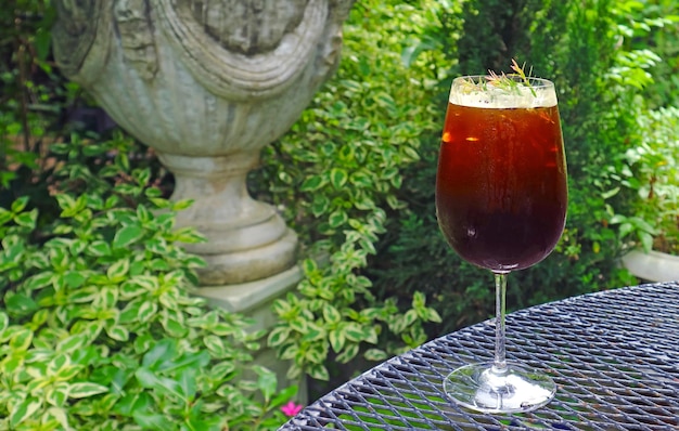 Vaso de café helado servido en la mesa de té del jardín