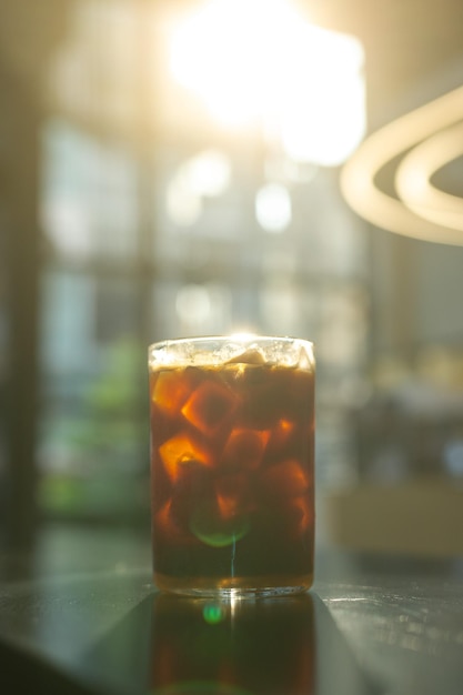 Un vaso de café helado se sienta en la barra de un bar.