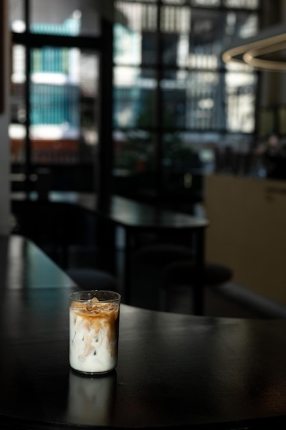 Un vaso de café helado se sienta en una mesa en un café.