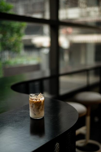 Un vaso de café helado se sienta en una mesa en un café.