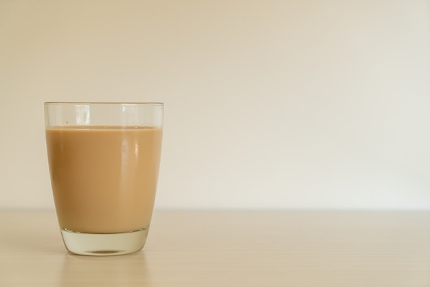 Vaso de café con leche con botellas de café listas para beber en la mesa