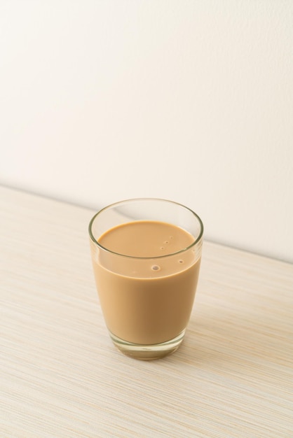 Vaso de café con leche con botellas de café listas para beber en la mesa