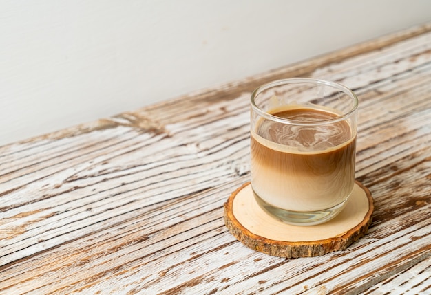 Vaso de café con leche, café con leche en una rodaja de madera