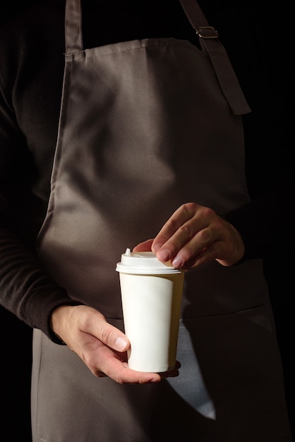 Foto un vaso de café en manos de un barista.