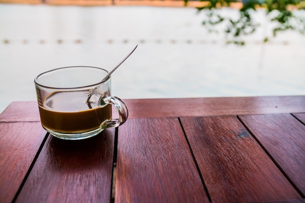 Vaso de café en la mesa de madera con fondo de río