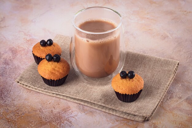 Vaso de café y muffins con frutos negros