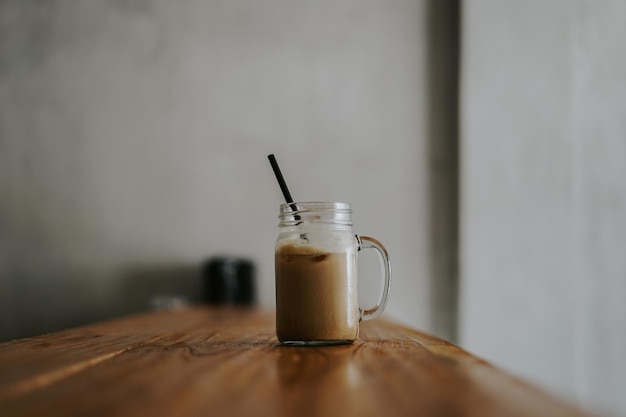 Un vaso de café con una pajita en la parte superior.