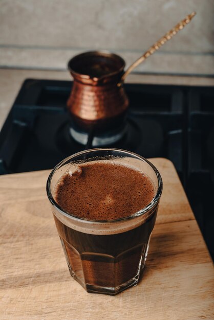 Un vaso de café turco elaborado en un fogón de cobre en la estufa