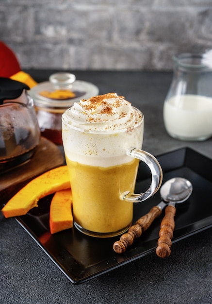 Un vaso de capuchino picante de calabaza en gris