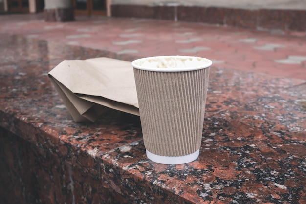 Vaso de cartón con comida callejera al aire libre.