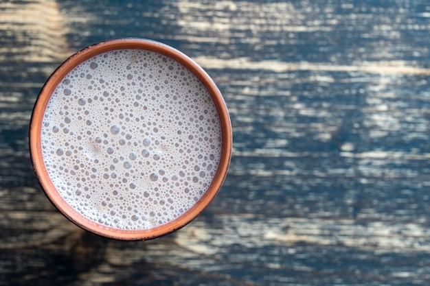 Vaso de cerámica de batido de chocolate en madera