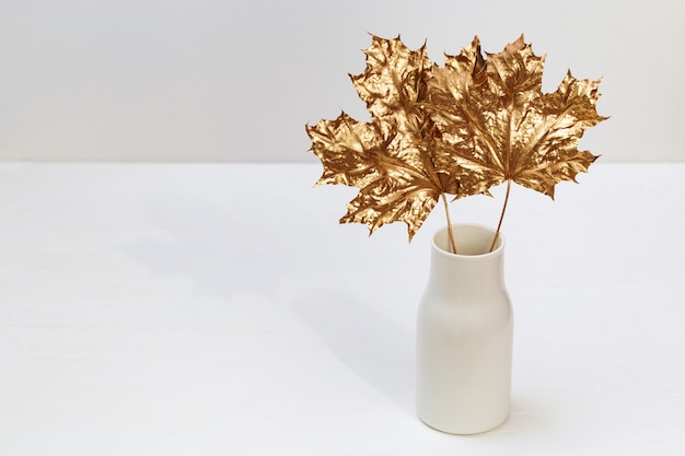 Foto vaso cerâmico com folhas douradas de marple.