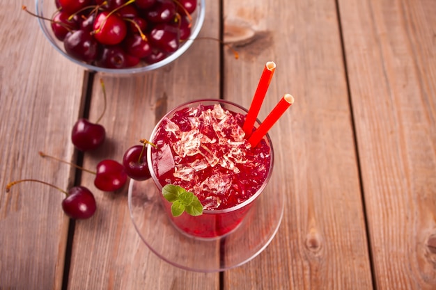 Vaso con cereza fresca hecha en casa dulce té helado o cóctel, limonada con menta. Refrescante bebida fría. Fiesta de verano.