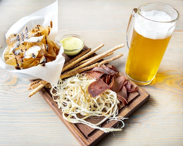 Vaso de cerveza y bocadillos salados en la mesa Vista superior