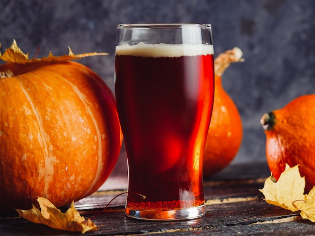 Un vaso de cerveza de calabaza en una mesa de madera