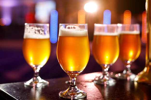 Un vaso de cerveza fría sobre la mesa de madera de un bar