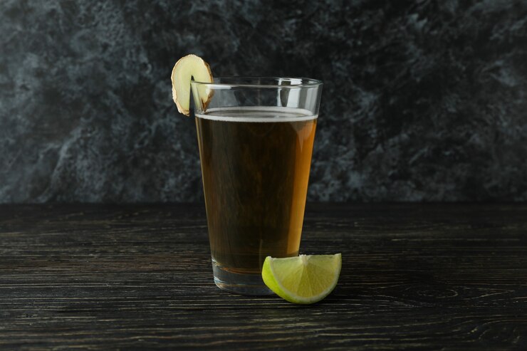 Foto vaso de cerveza de jengibre y el ingrediente en la mesa de madera