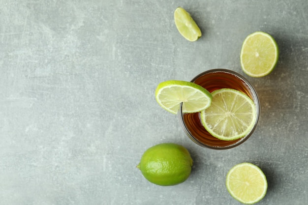 Vaso de cerveza y limones en textura gris