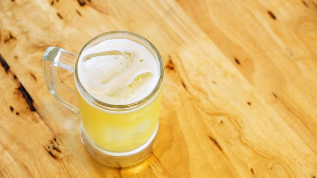 Un vaso de cerveza en una mesa de madera