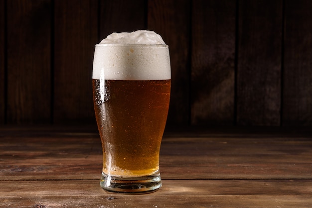 Vaso de cerveza en la mesa de madera