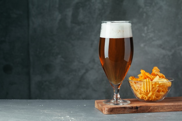 Vaso de cerveza oscura con tazón de aperitivos de cerveza de cerca