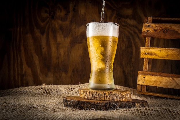 Un vaso de cerveza con un trozo de pan al lado.