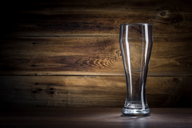 Vaso de cerveza vacío sobre un fondo de madera