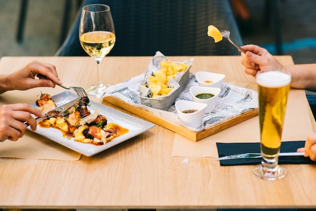 Un vaso de cerveza y vino en una mesa con platos dos chicas almuerzan juntas en un restaurante en la terraza