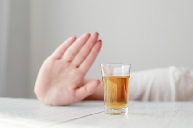 Foto vaso de chupito con alcohol y mano no muestra depresión alcohólica