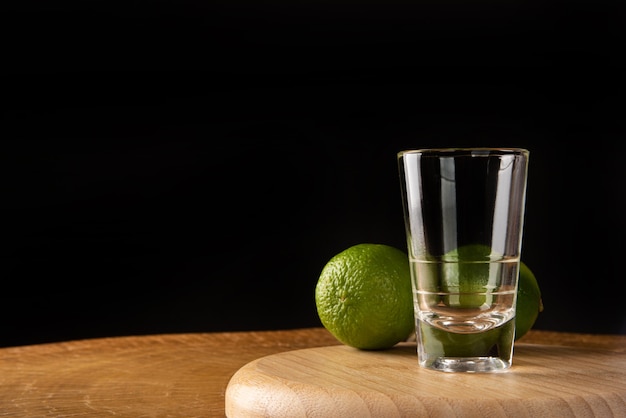 Vaso de chupito vacío y dos limones